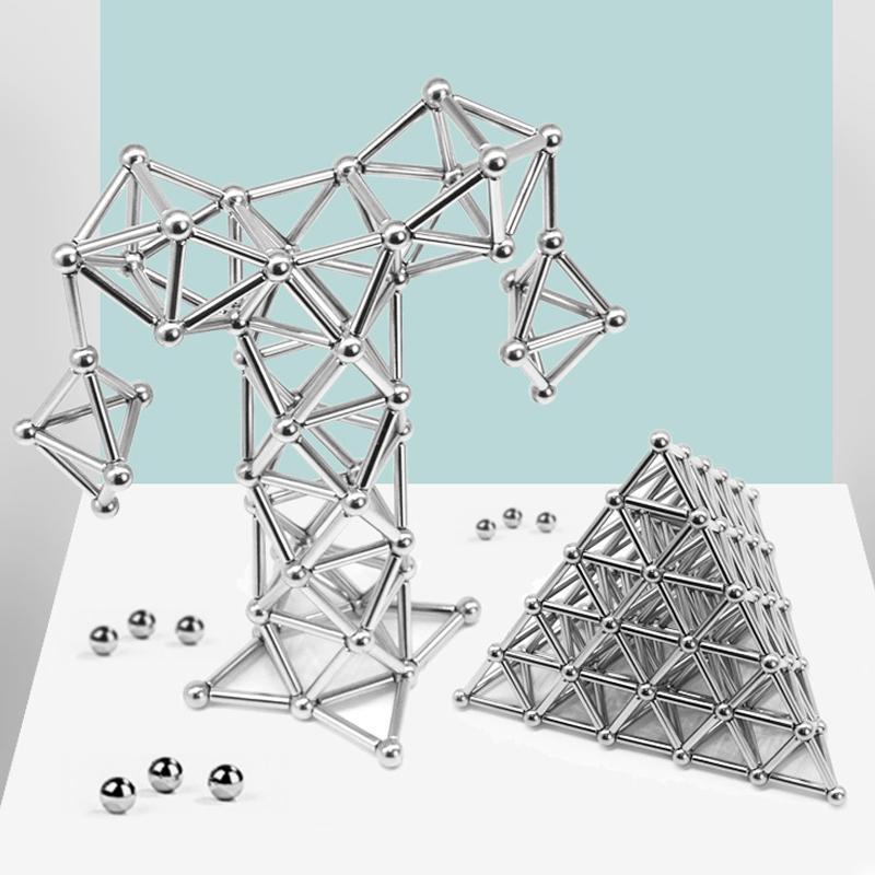 Two structures made from silver magnetic rods and spheres, one resembling an abstract shape and the other a triangular pyramid on white surface