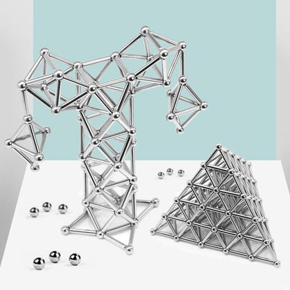 Two structures made from silver magnetic rods and spheres, one resembling an abstract shape and the other a triangular pyramid on white surface