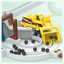 Yellow toy forklift with black wheels lifting black balls on a gray curved track with brown mechanical arm