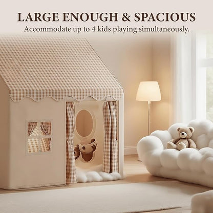 Beige fabric playhouse with checkered roof and curtains next to white plush sofa with teddy bear in cozy room