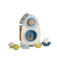 Wooden rocket-shaped shape sorter toy with star, moon, cloud, and flower pieces on white background