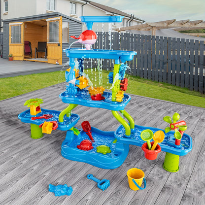 Outdoor blue and green water play table with spinning wheels, funnels, water channels, and colorful accessories on wooden deck