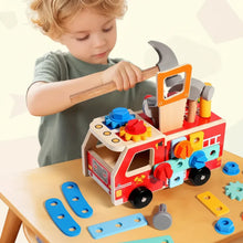 Young child playing with colorful wooden fire truck toy featuring gears, nuts, and a hammer on table