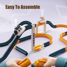 Hands assembling yellow and dark green flexible track pieces with two small train-shaped vehicles on elevated curved tracks