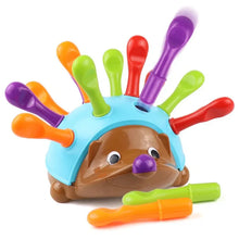Brown hedgehog toy with colorful plastic spoons sticking out of a blue dome shell on white background