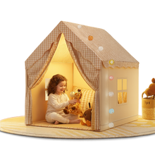 Child playing inside a cozy playhouse with toys on a white background